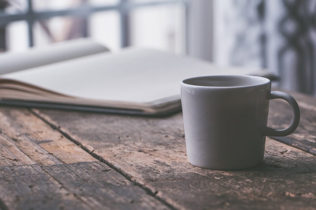 Coffee cup and open notebook